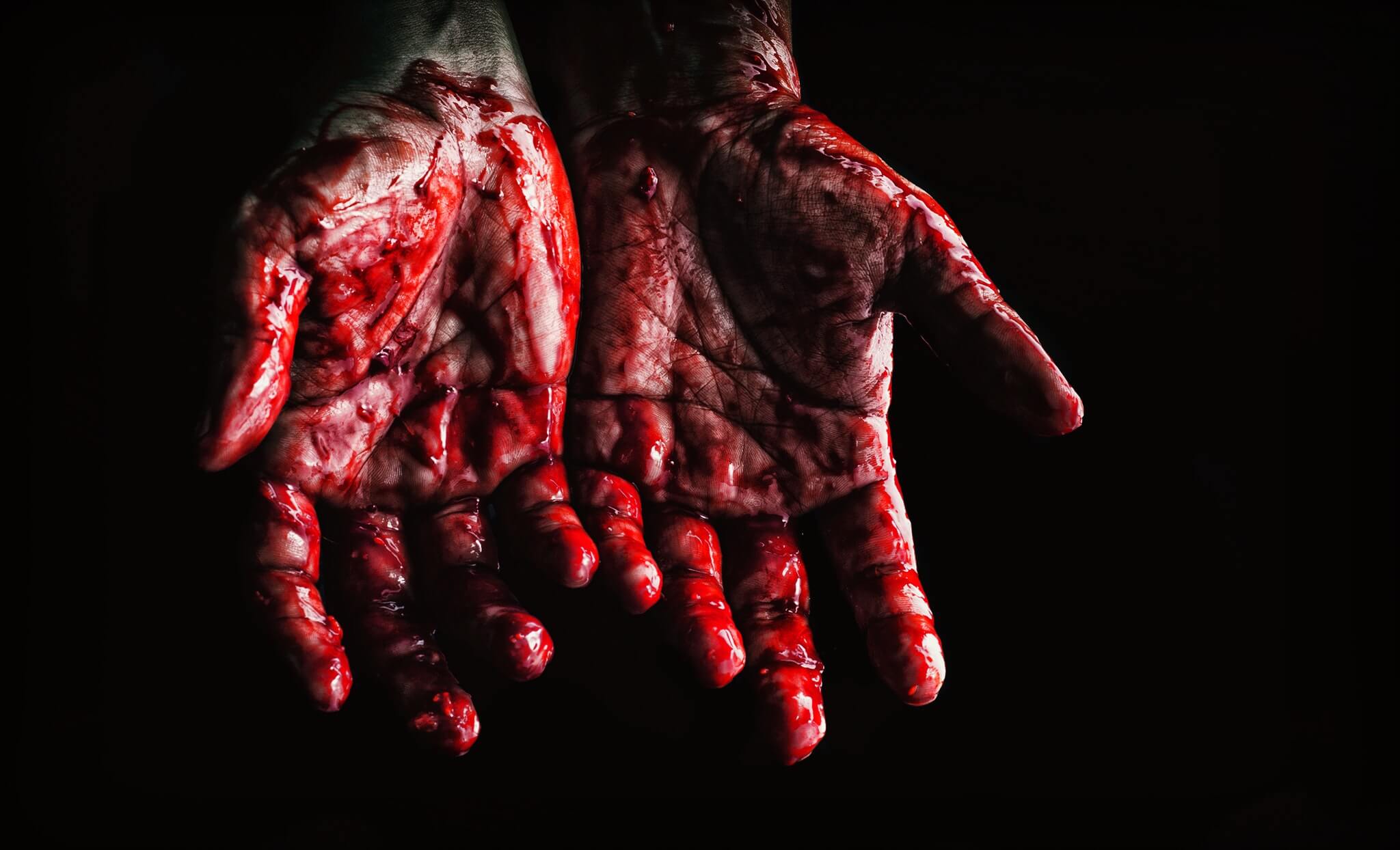 Twee handen die volledig onder het bloed zitten, mogelijk van een seriemoordenaar die net een moord heeft gepleegd